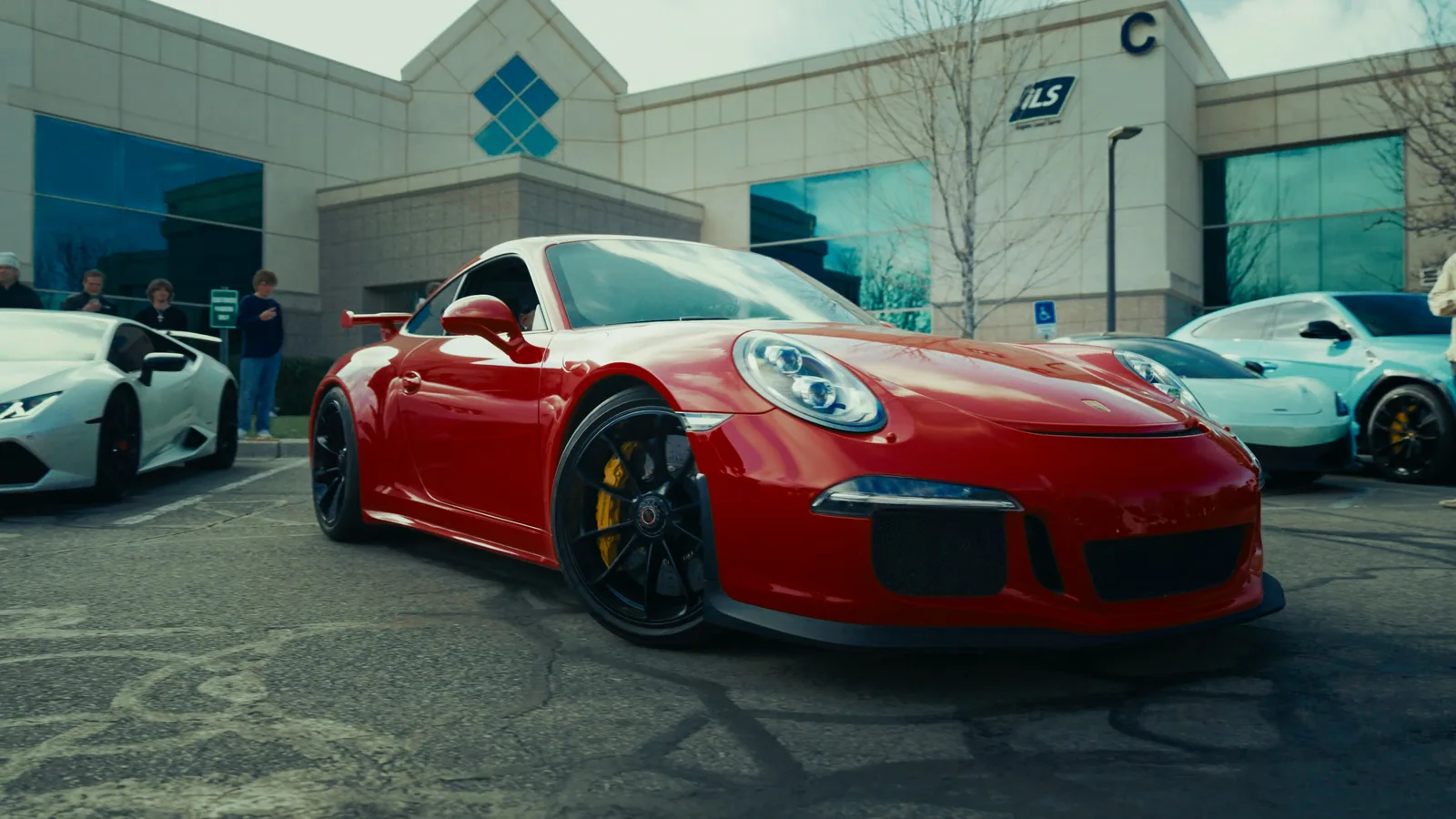 A red sports car parked among other luxury cars.
